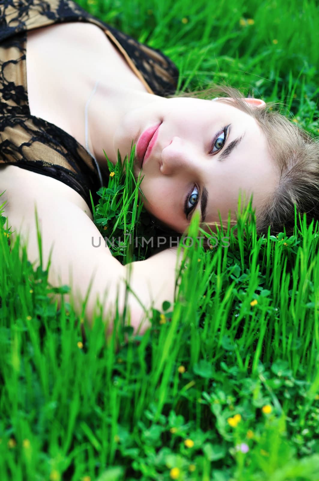 beautiful young teen girl laying on the spring meadow