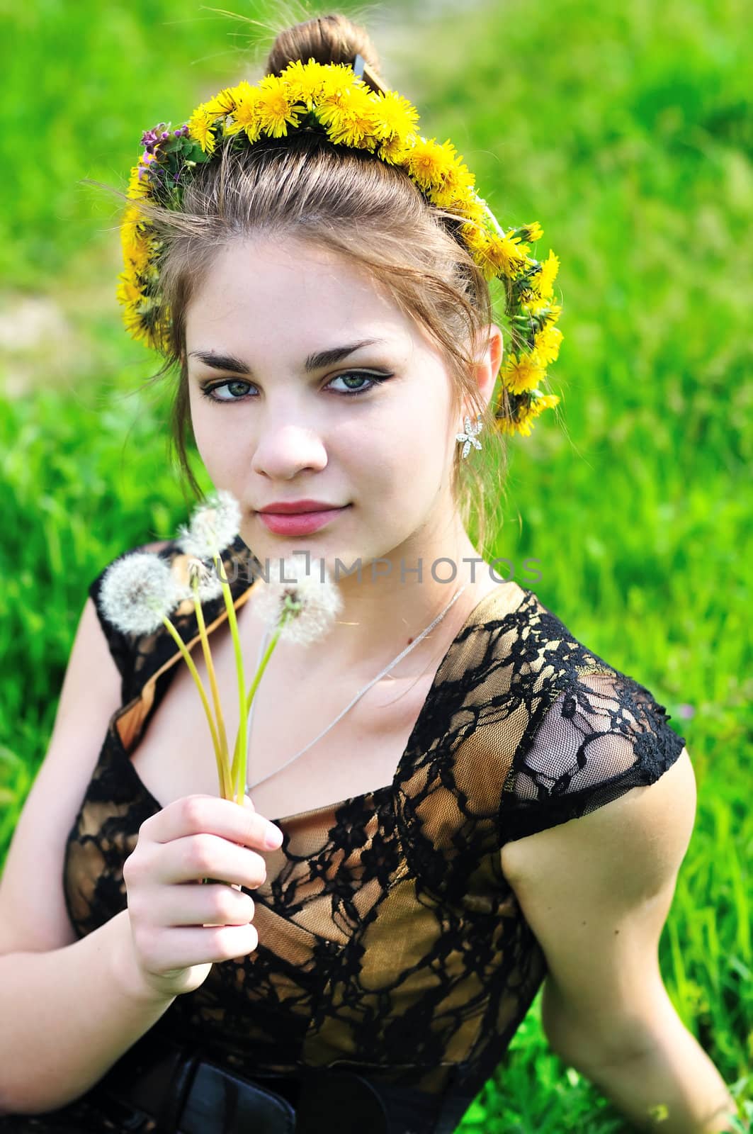 girl with dandelions on her head and in her hand
