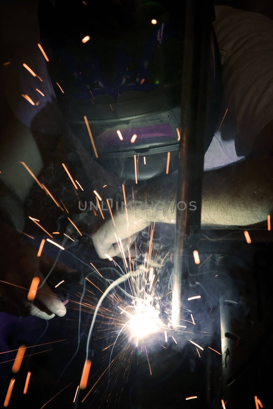 Welder working on the metal fork of a motorcycle