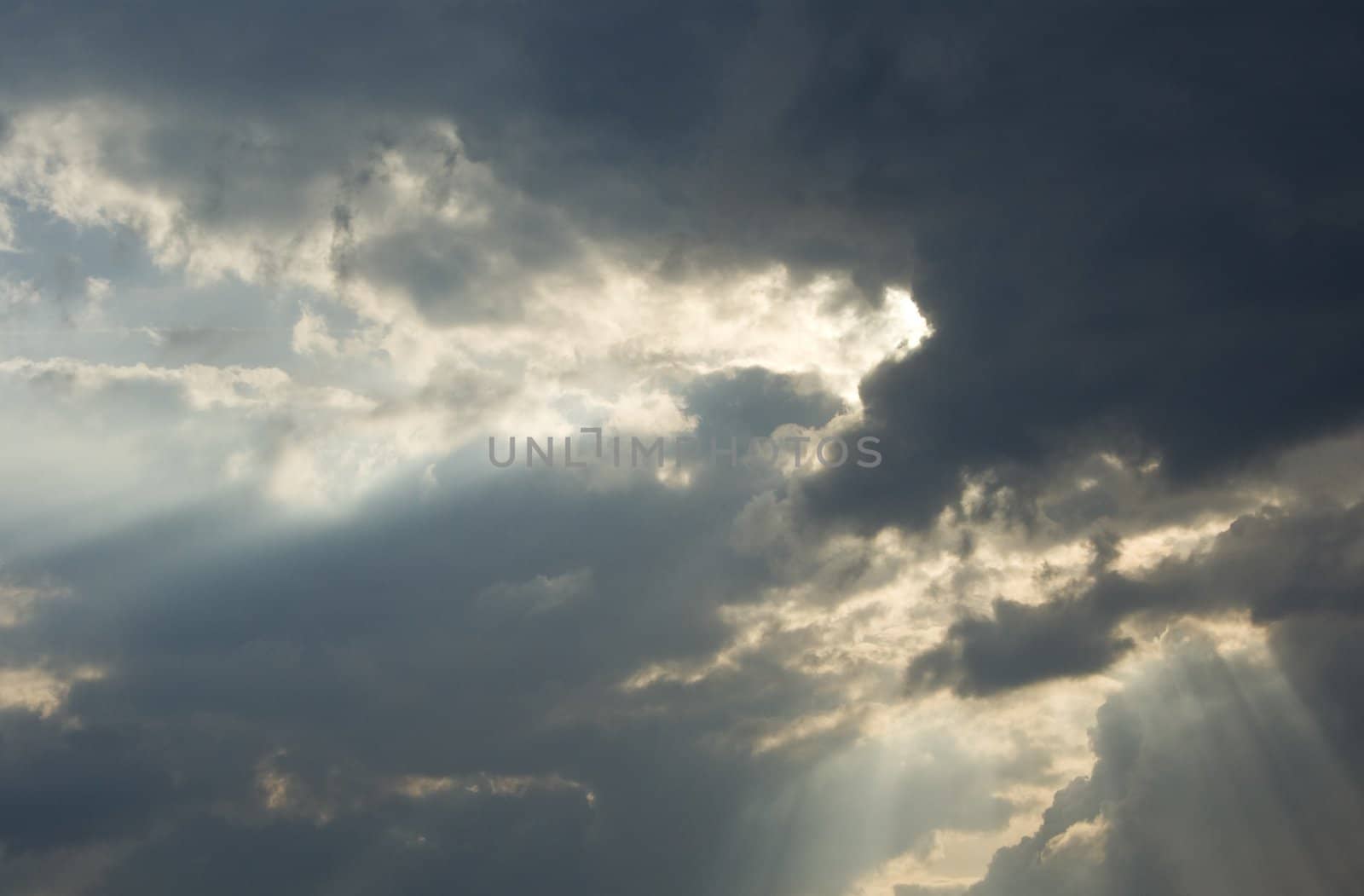 Big rays of light through grey clouds