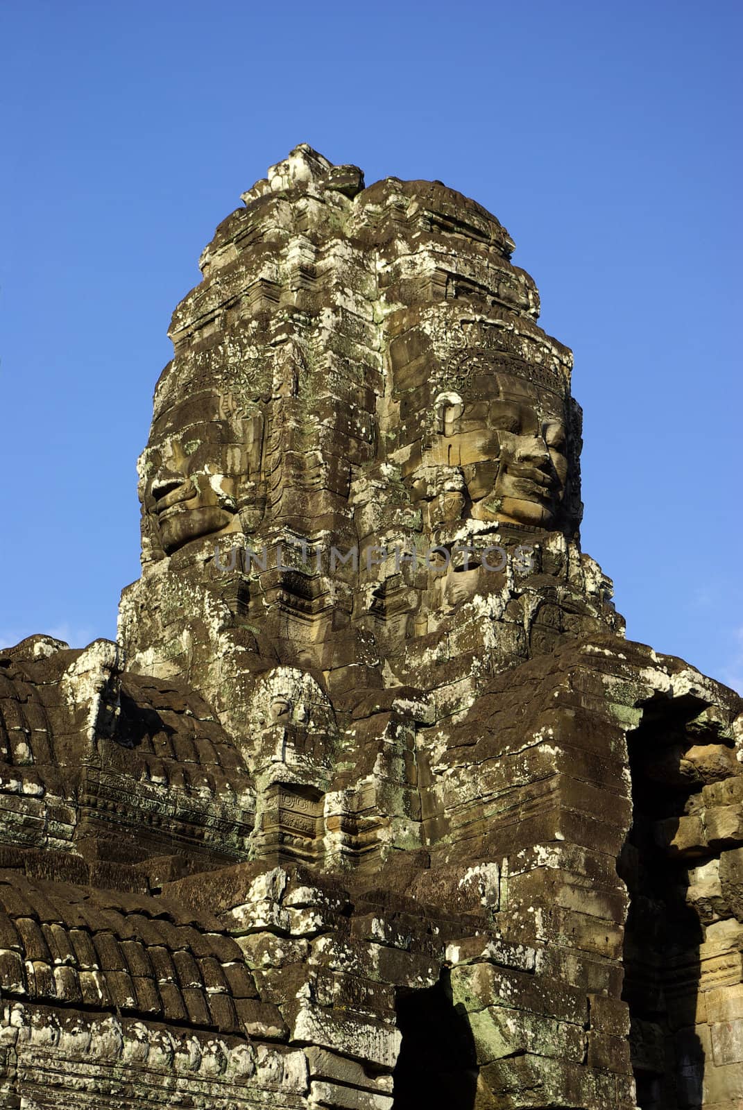 A view below a tower of Bayon Temple at Angkor where you can see faces of stone