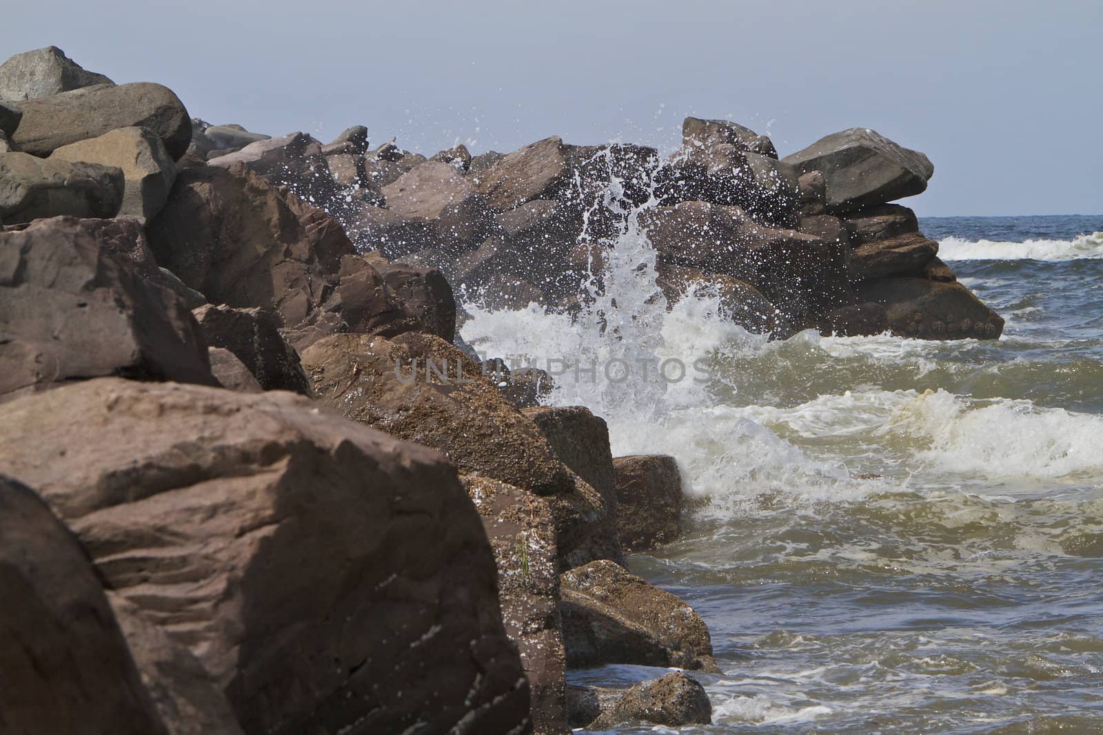 Water plume in the air from ocean waves hitting rock breakers