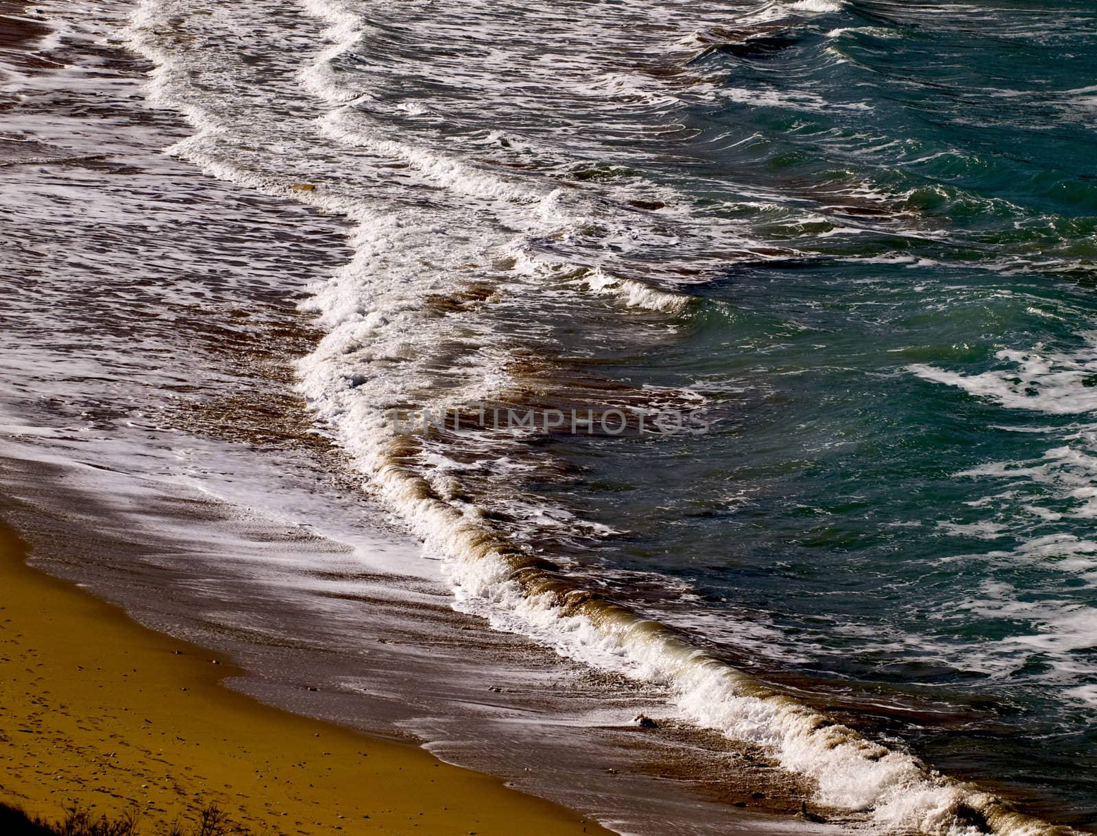 Waves crashing on the coast on a beach in Malta