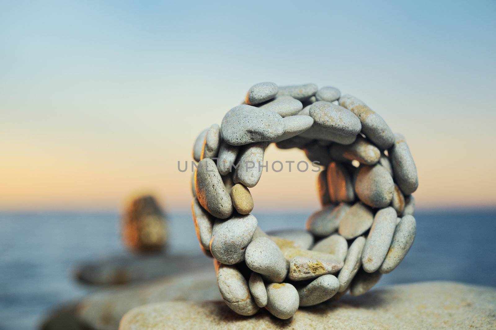 Sphere from a sea pebble in the summer evening on a beach