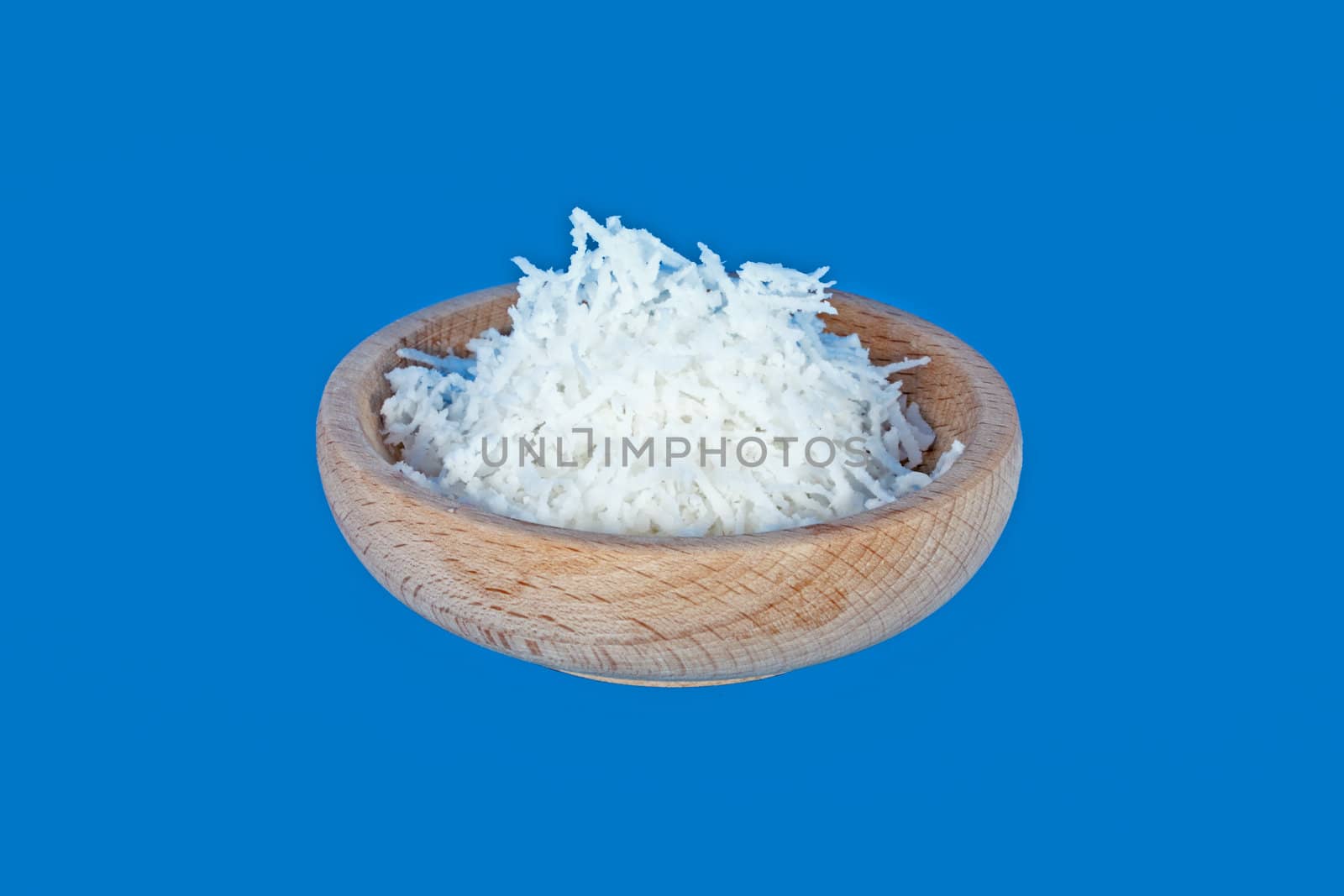 Wooden bowl full of coconut meal isolated on blue
