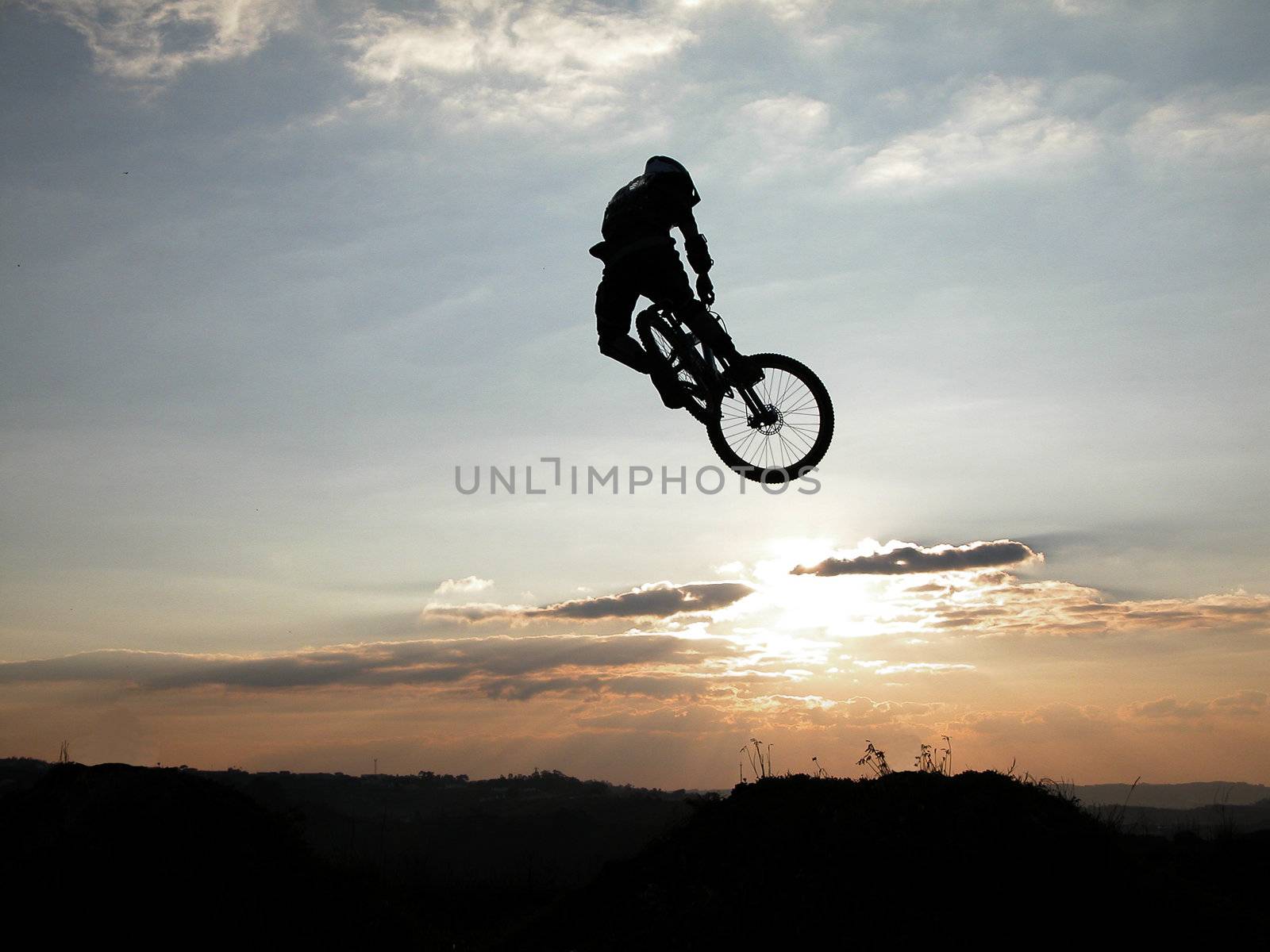 Mountain bike jump at the sunset