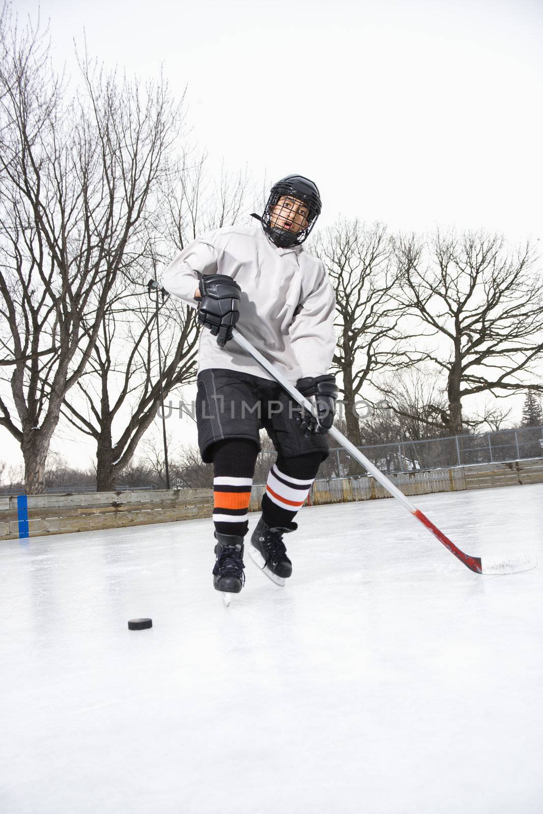 Boy playing ice hockey. by iofoto