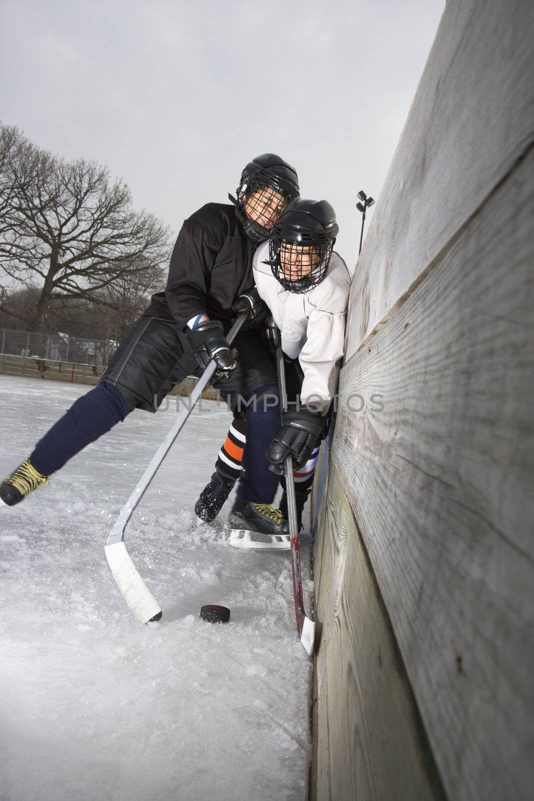 Boys playing ice hockey. by iofoto