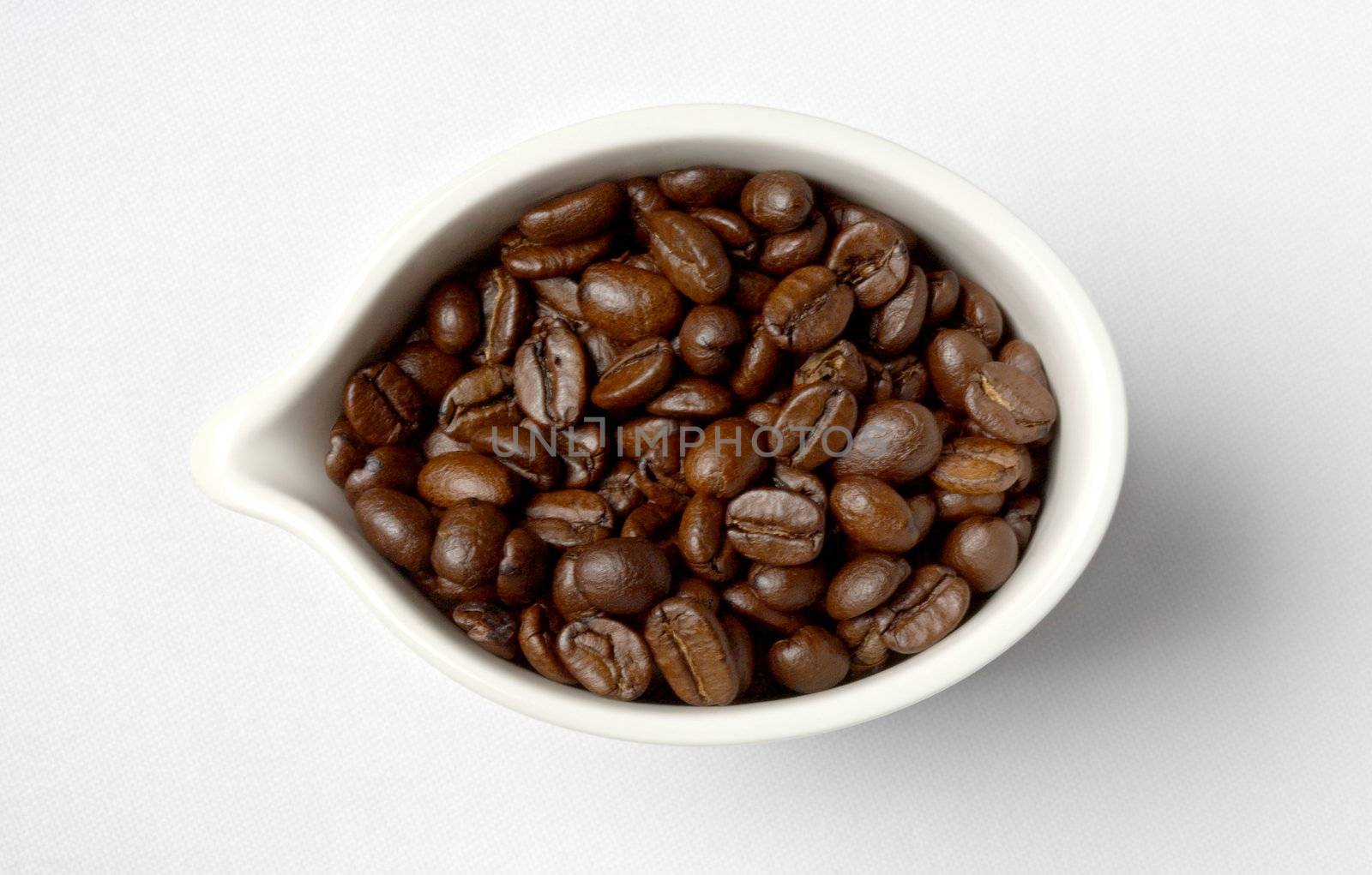 white porcelain cup full of colombian coffee beans