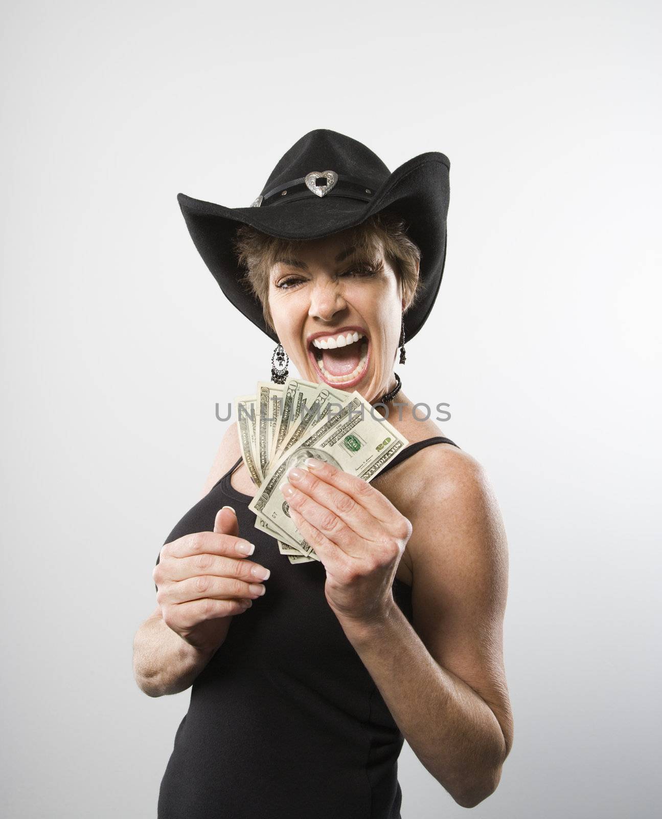 Woman making facial expression and holding twenty dollar bills in hand.