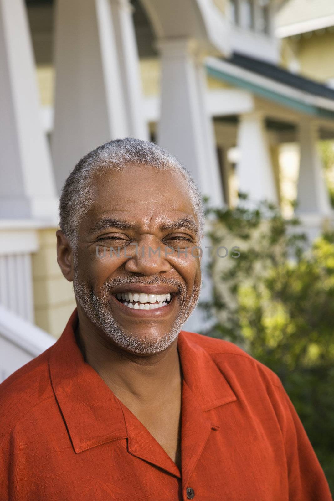 African American middle aged man smiling at viewer.