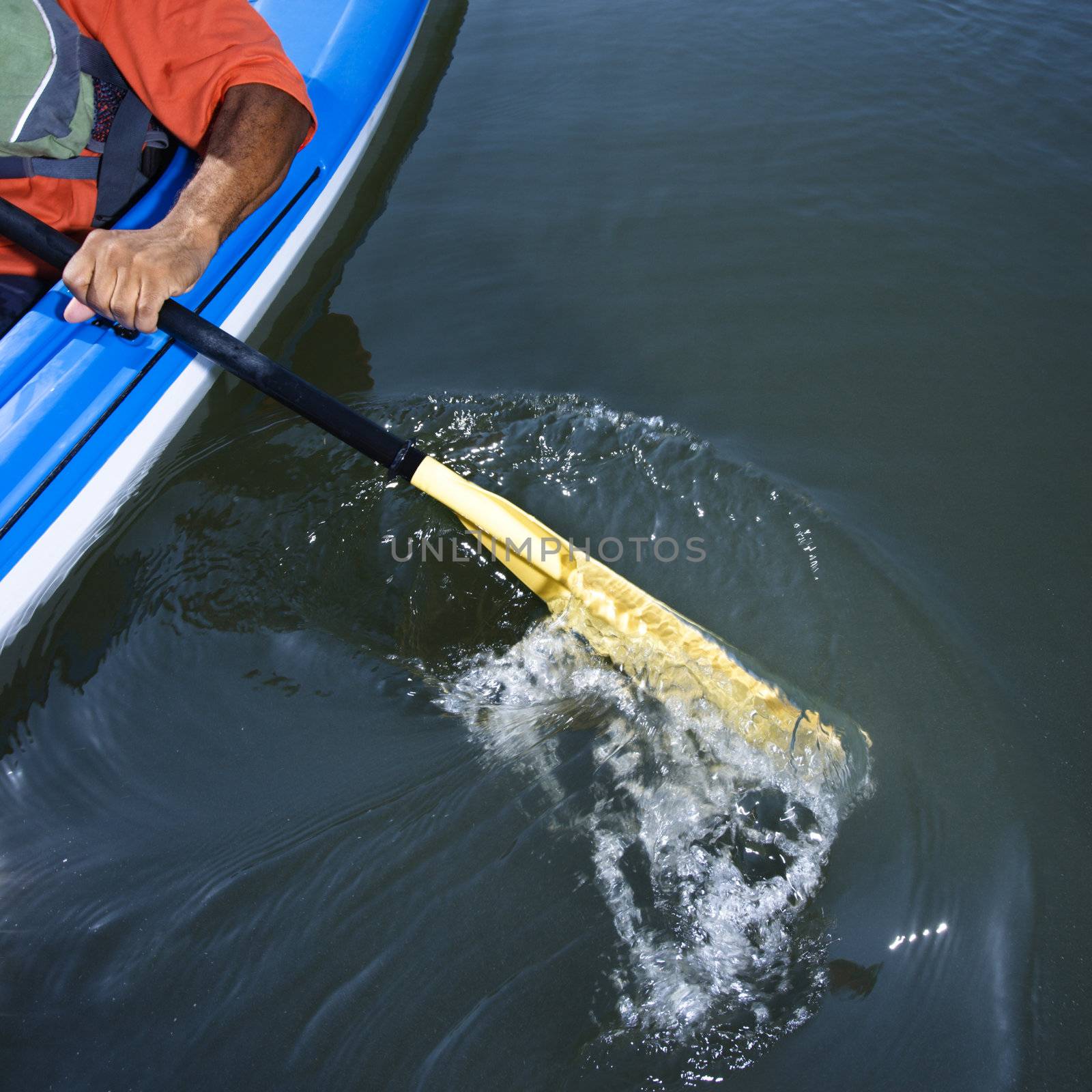 Man paddling kayak. by iofoto
