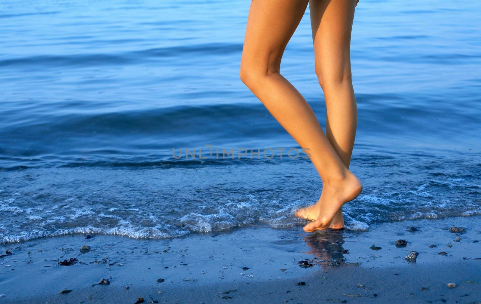 long legs of tall lady walking in water