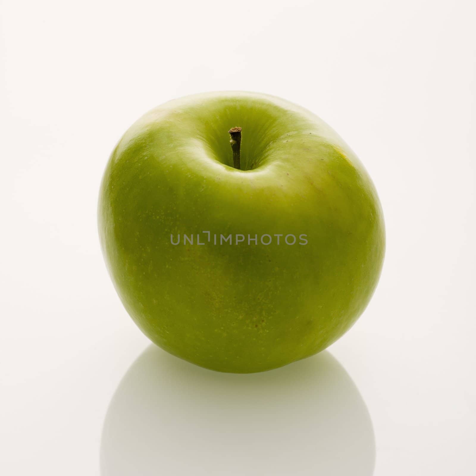 Still life of whole green apple on white background.