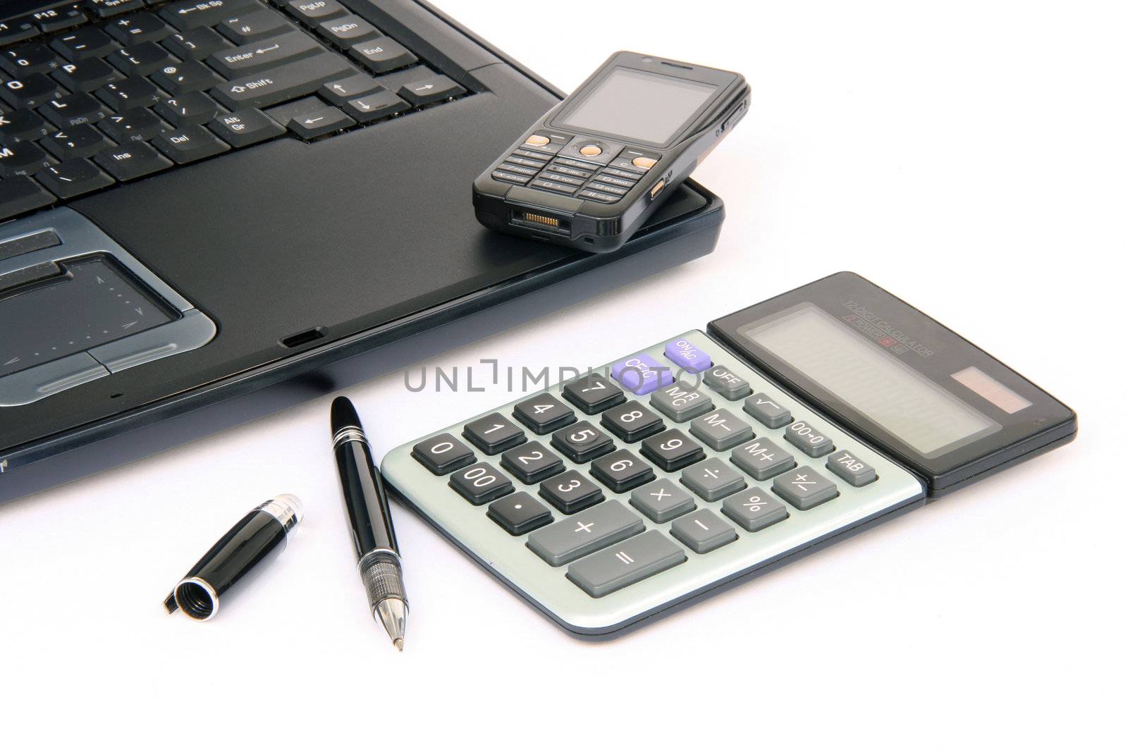 laptop detail with pen cellphone and calculator isolated on white background