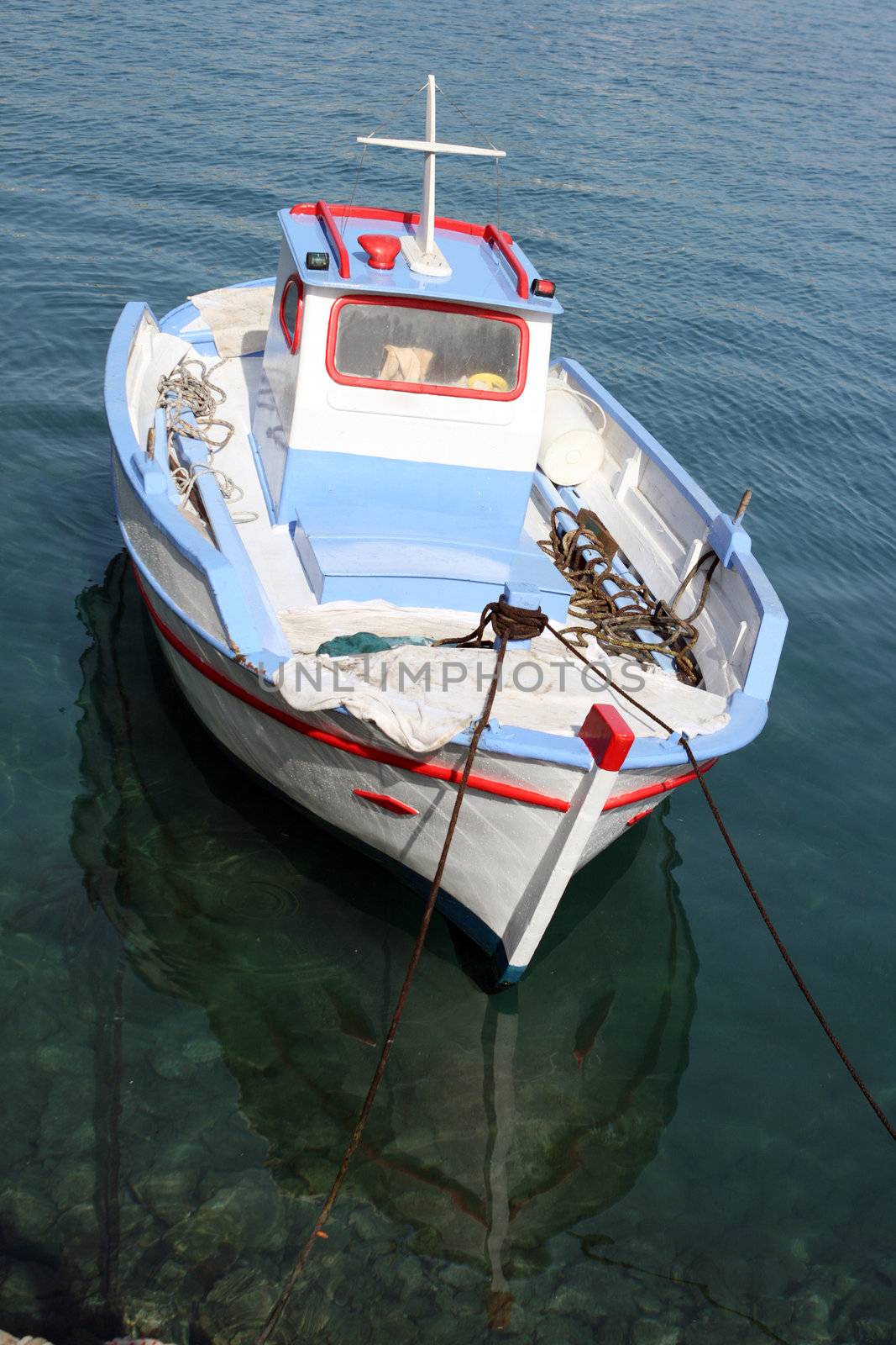 colorful traditional greek small wooden fishing boat moored