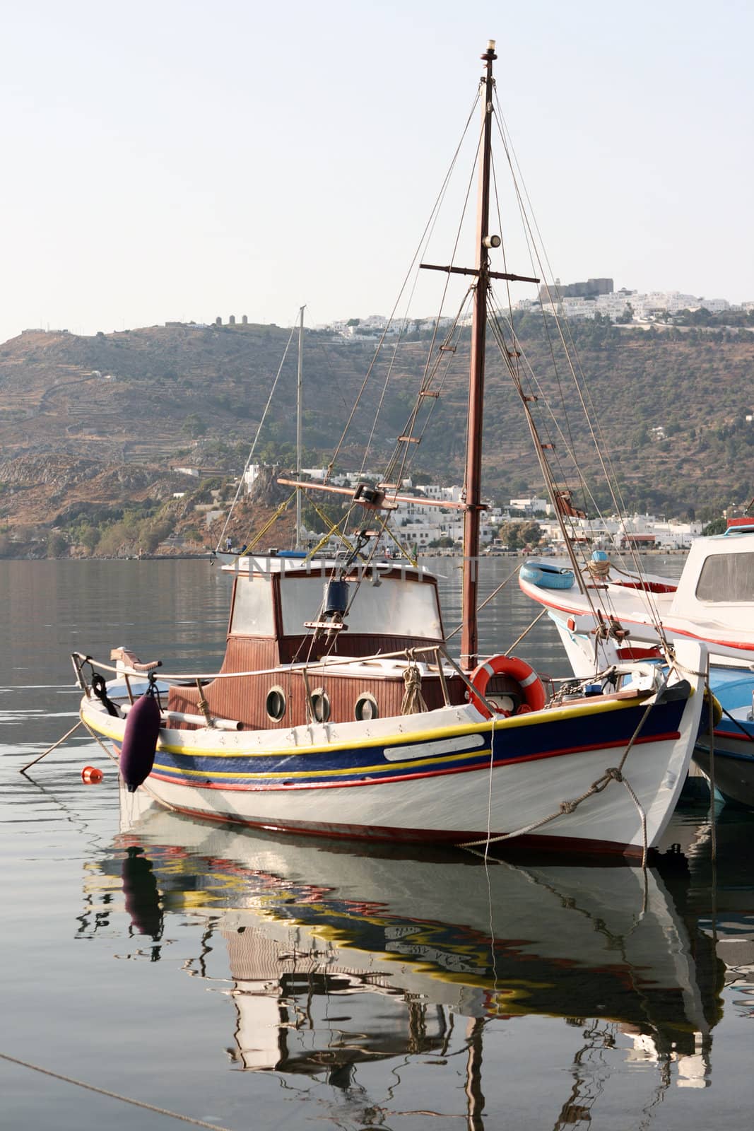 boats and reflections with background skala and chora of patmos island greece dodecanese