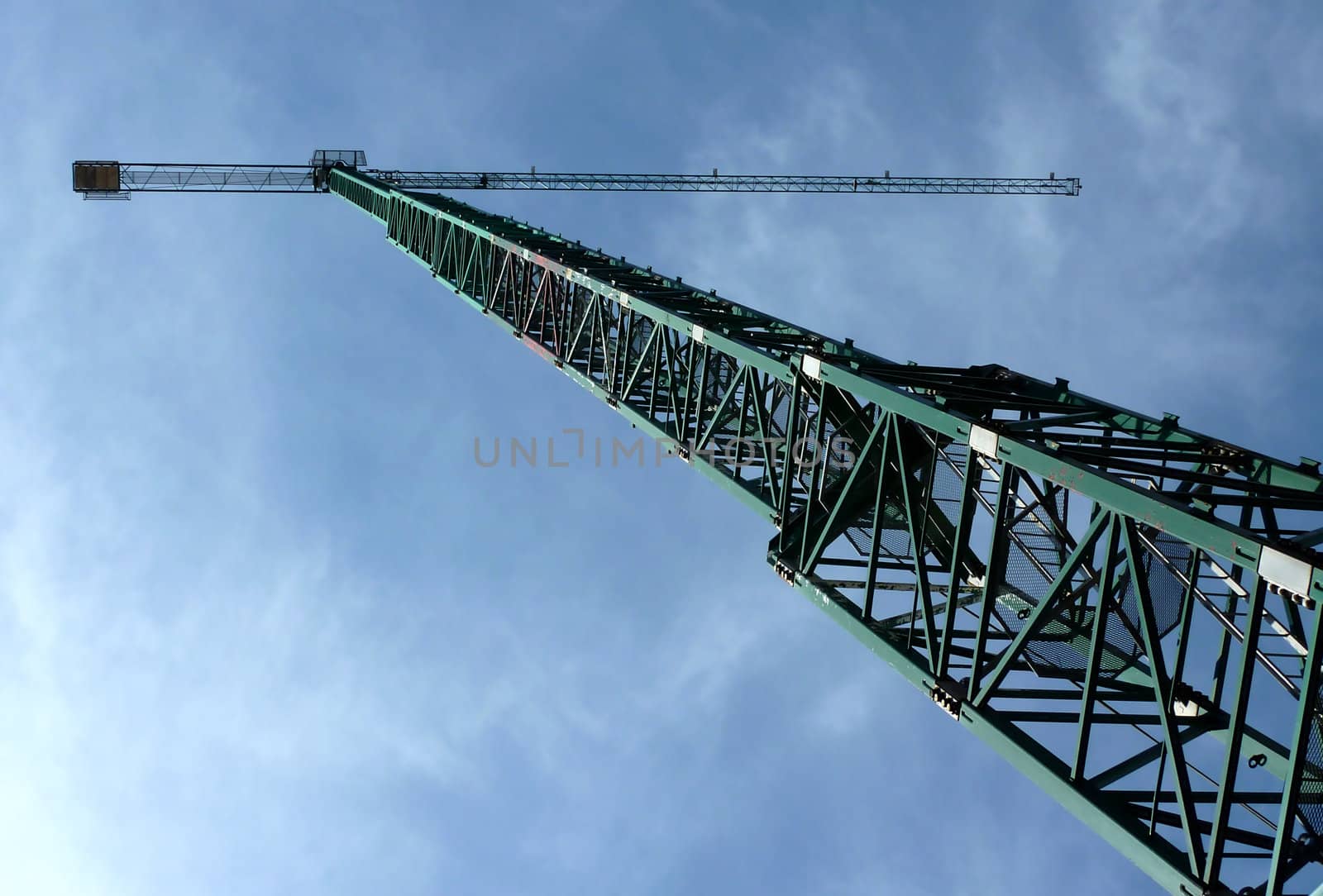 Big green crane with a background of a cloudy blue sky