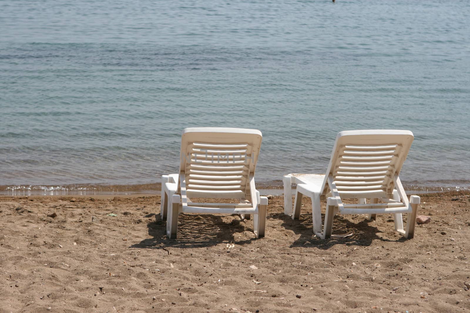 two white beach chairs by the sea patmos island greece