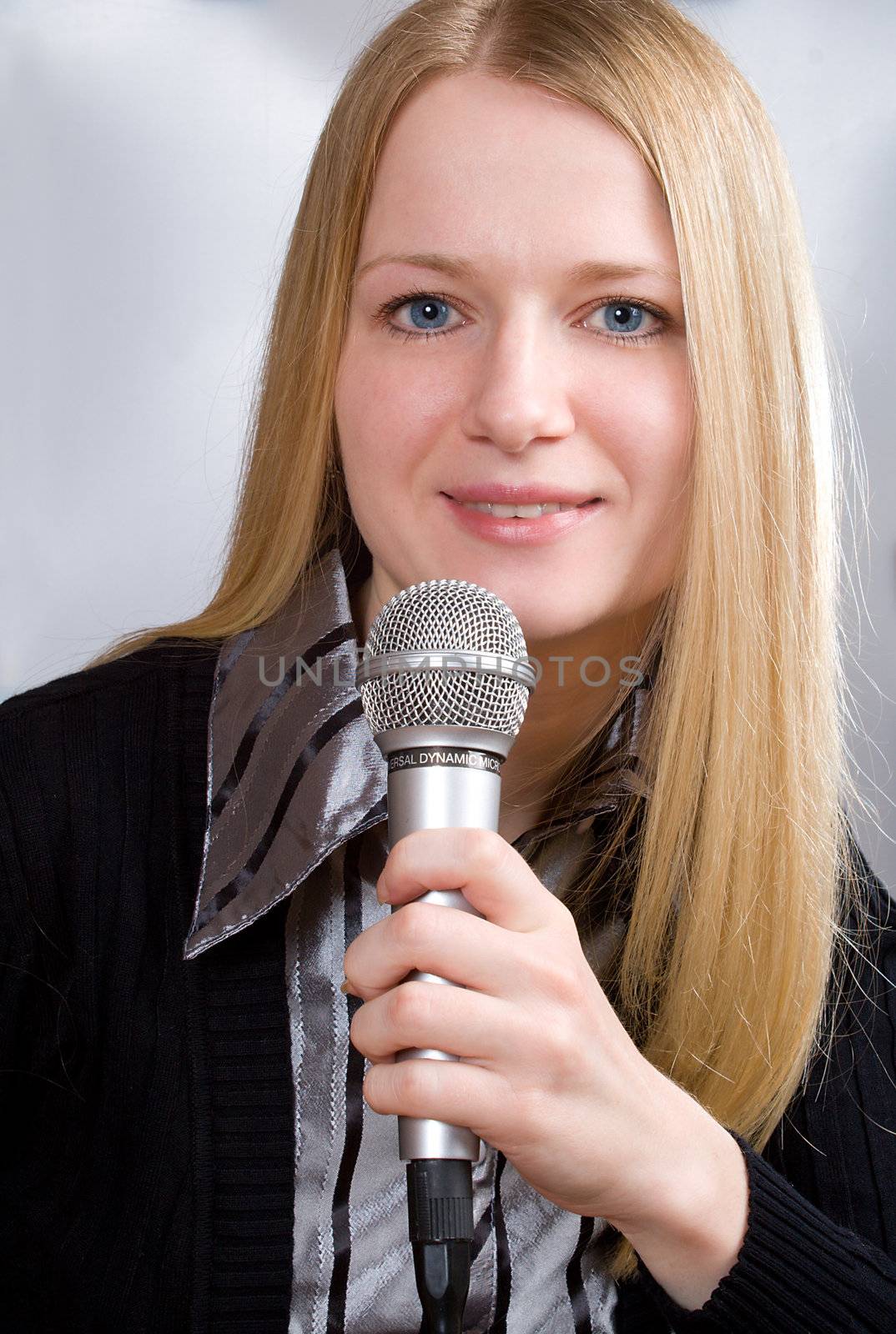 portrait of young woman singing into microphone