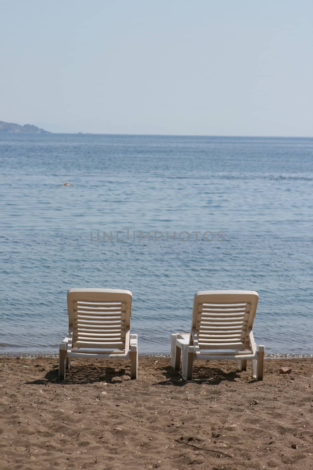 two white beach chairs by the sea patmos island greece