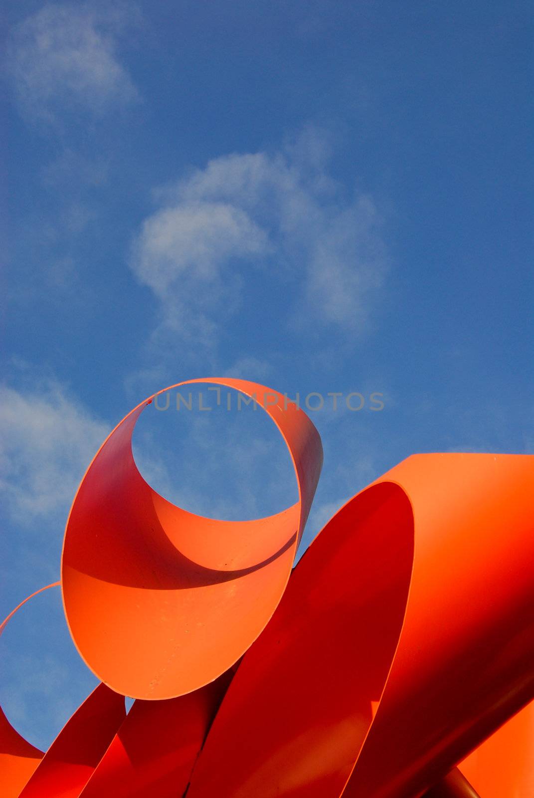 orange sculpture and blue sky behind