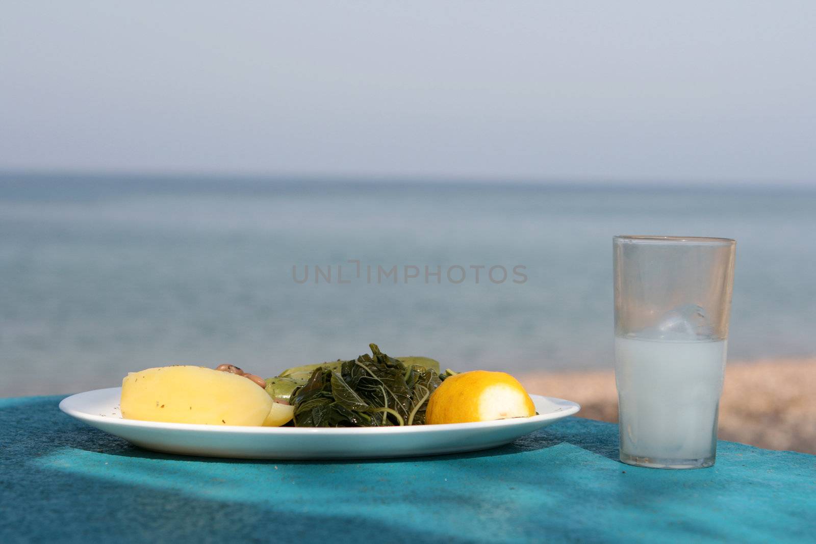 sea sky and food boiled mixed vegetables salad with glass of ouzo greece