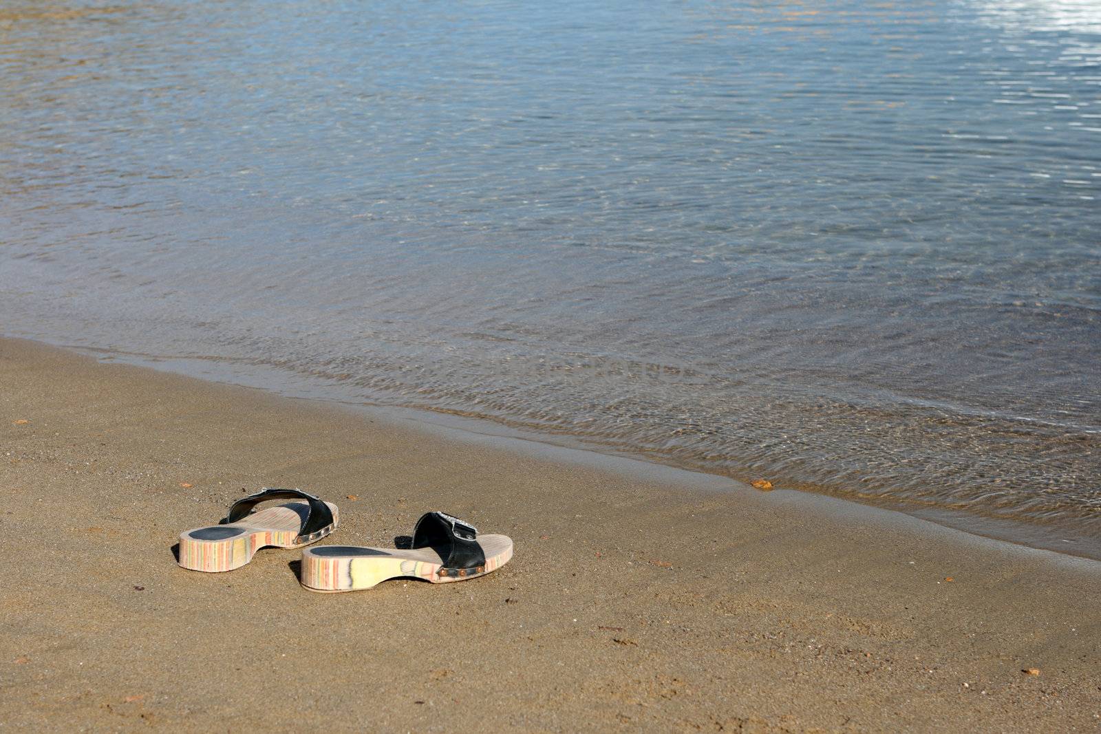 couple of woman sea slippers on the beach with copy space