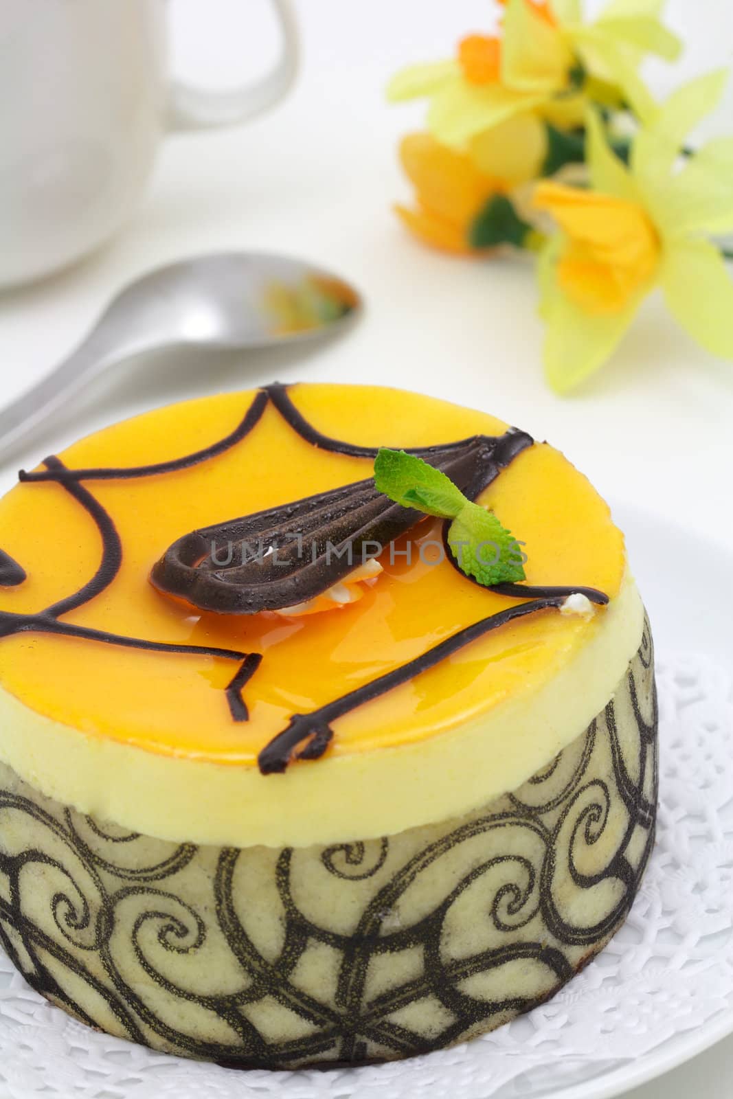 Mango chocolate cake decorated with mint leaves and swirls 
