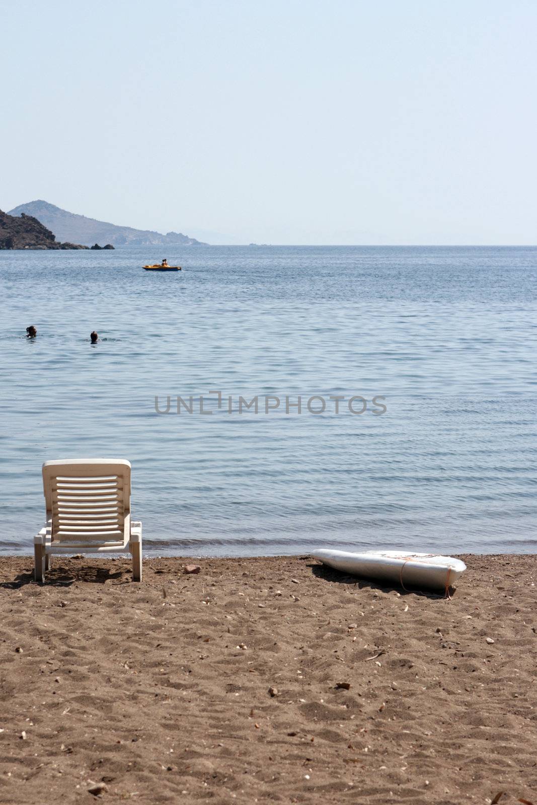 people swimming and  sunbed and surf board by the sea patmos island greece