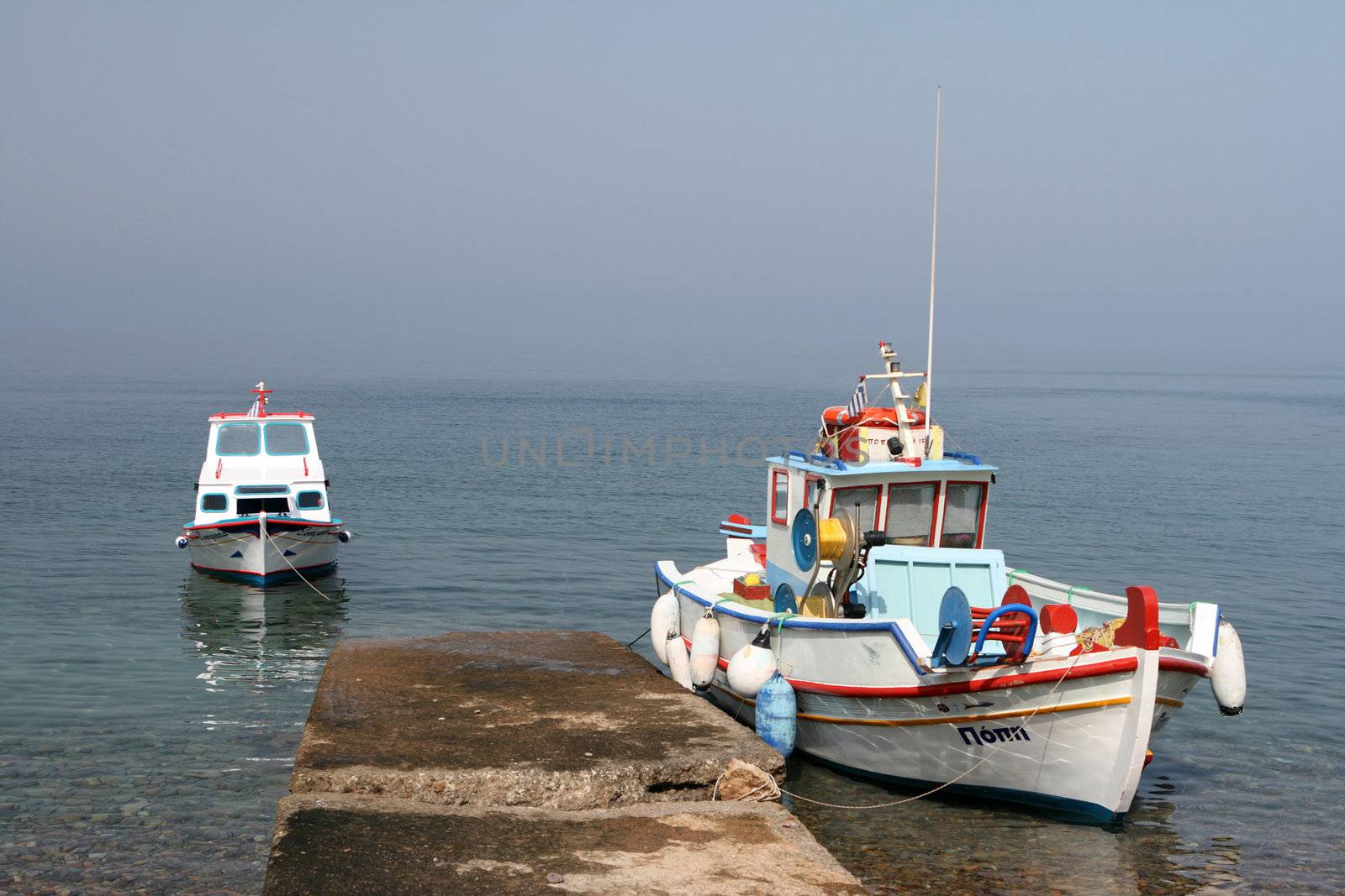 two fishing boats moored at lampi beach patmos  island greece