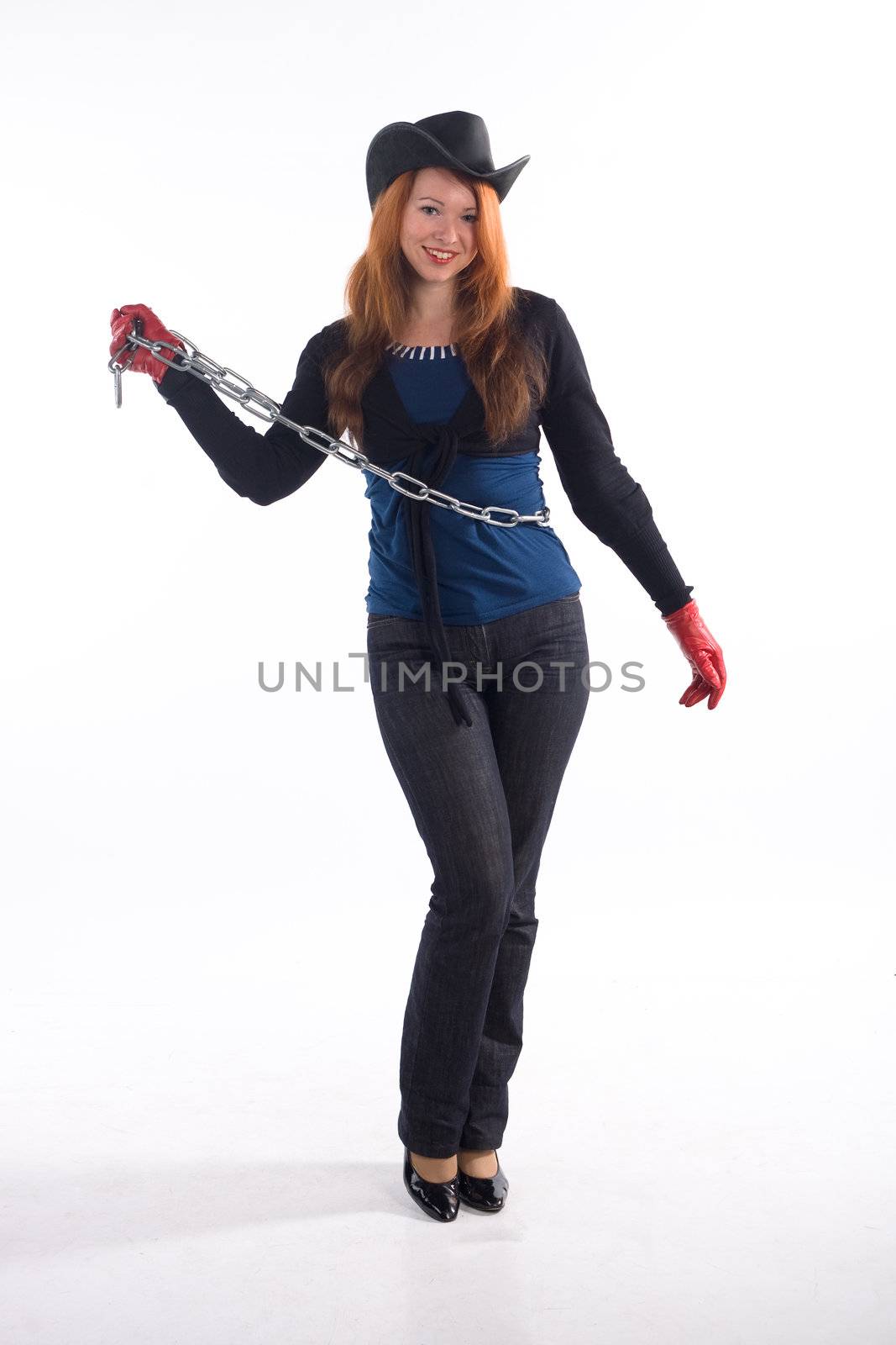 Young girl with red gloves, chain and black hat standing on white background
