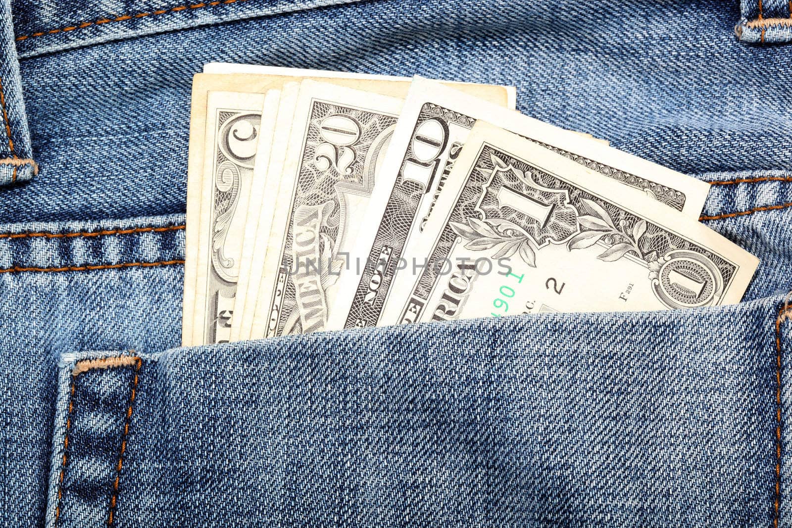 closeup detail dollar notes in back pocket of jean