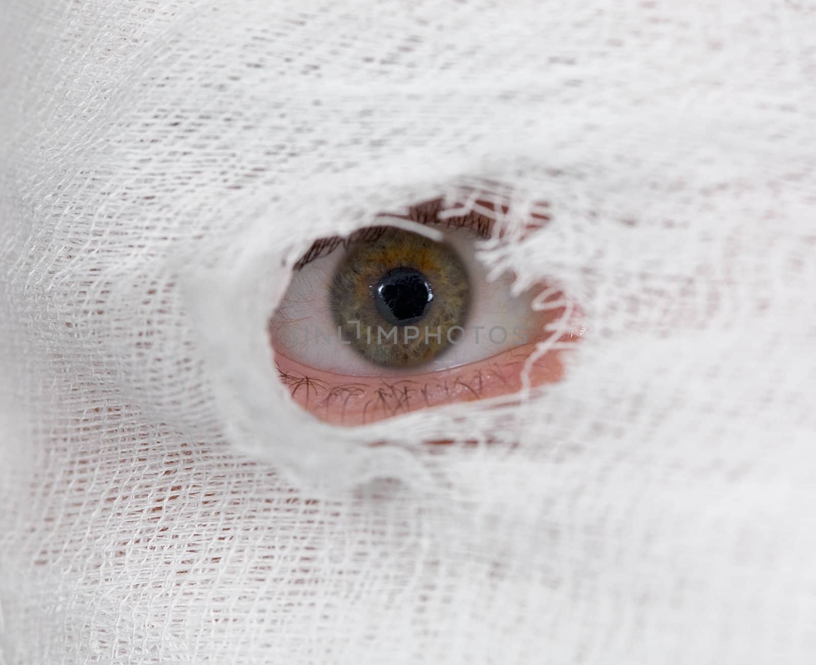 Male eye looking on hole in bandage