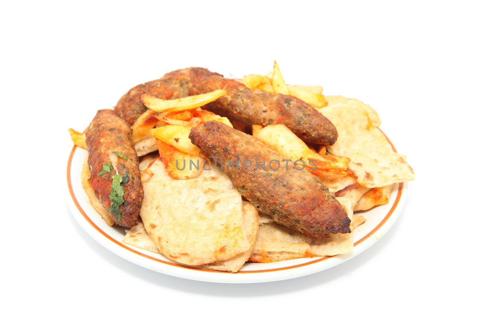 kebab plate with fried potatos and four stakes isolated on white background