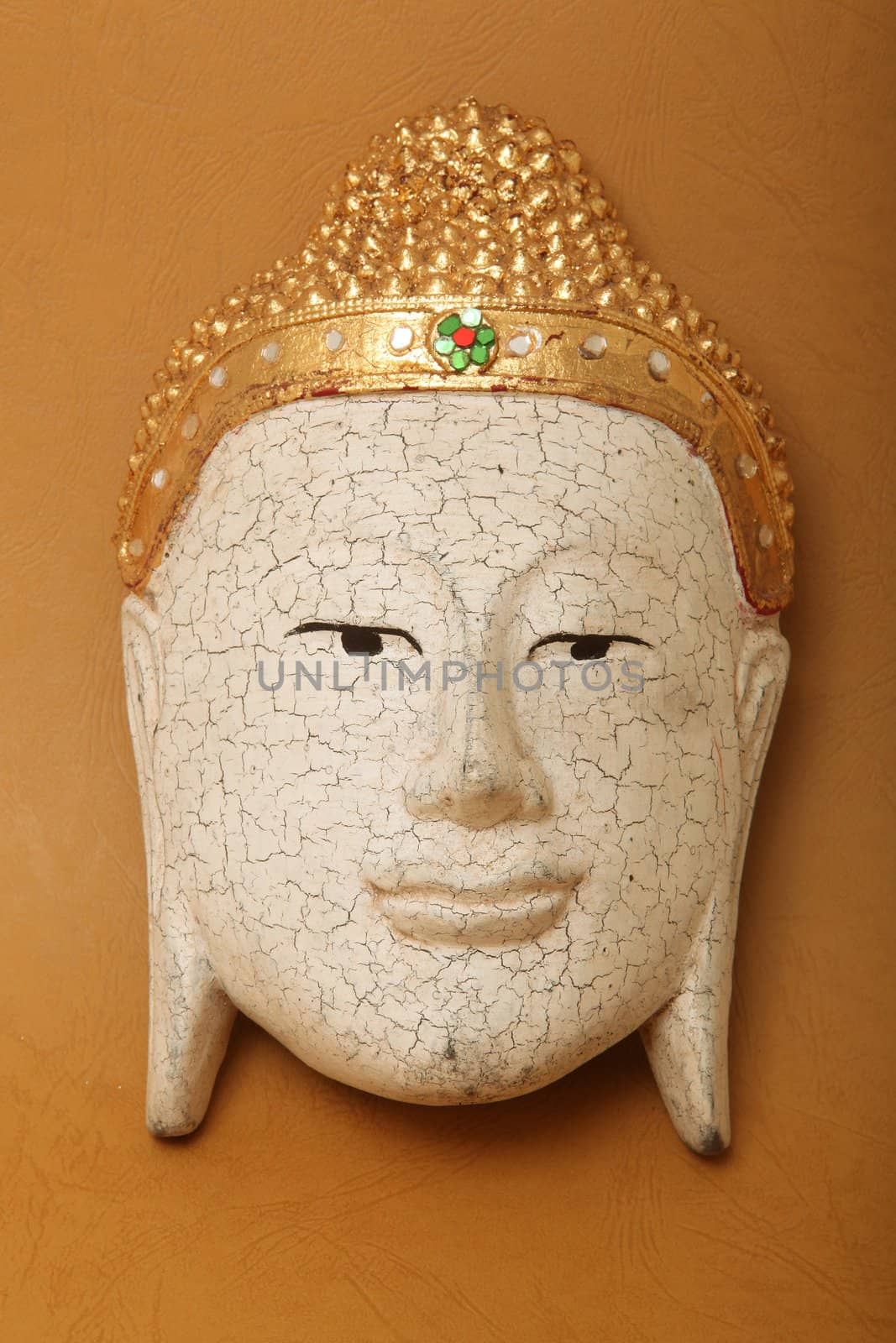 handcrafted wooden buddha face decorative mask on yellow background 