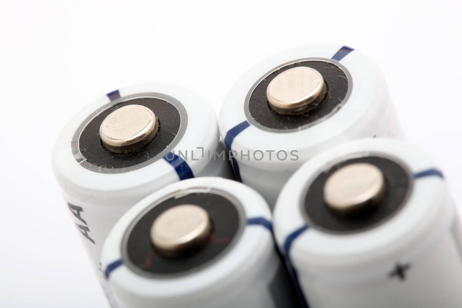 four white alkaline batteries on white background with copyspace