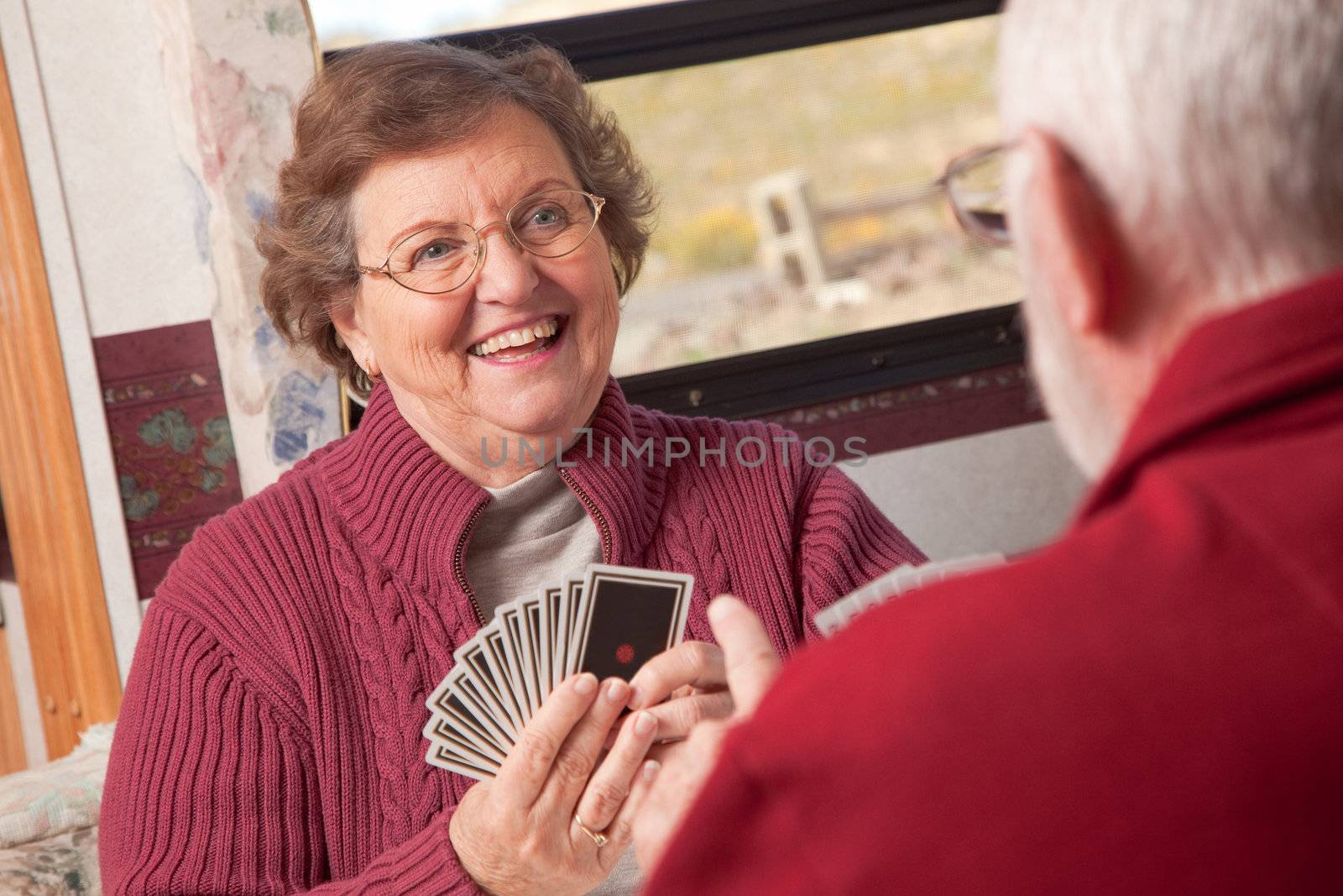 Happy Senior Adult Couple Playing Cards in Their RV.