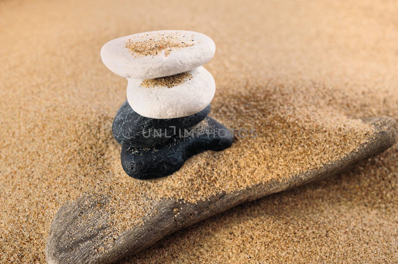 White and black sea pebble in a pile on sand