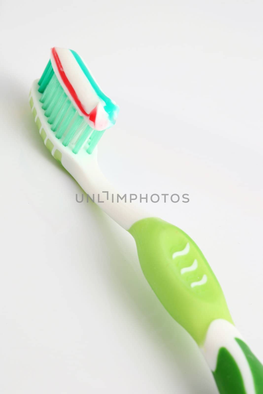 one toothbrush with paste on white background and copyspace