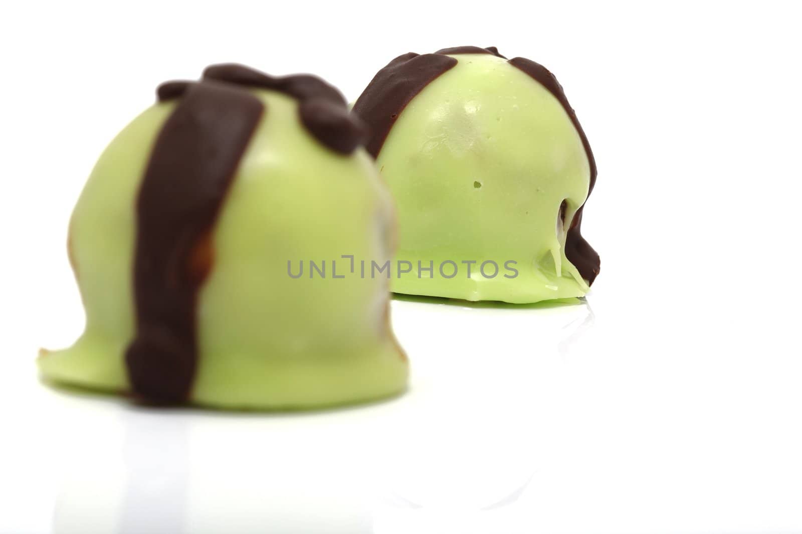 closeup two green sweets with reflection isolated on white background and copyspace