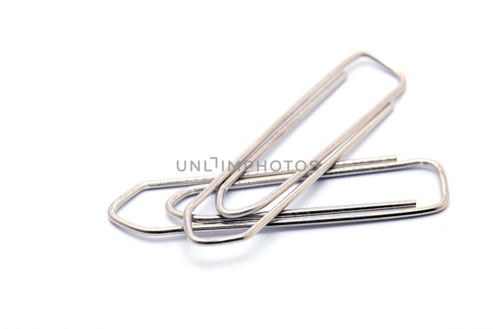 two metallic paper clips isolated on white background