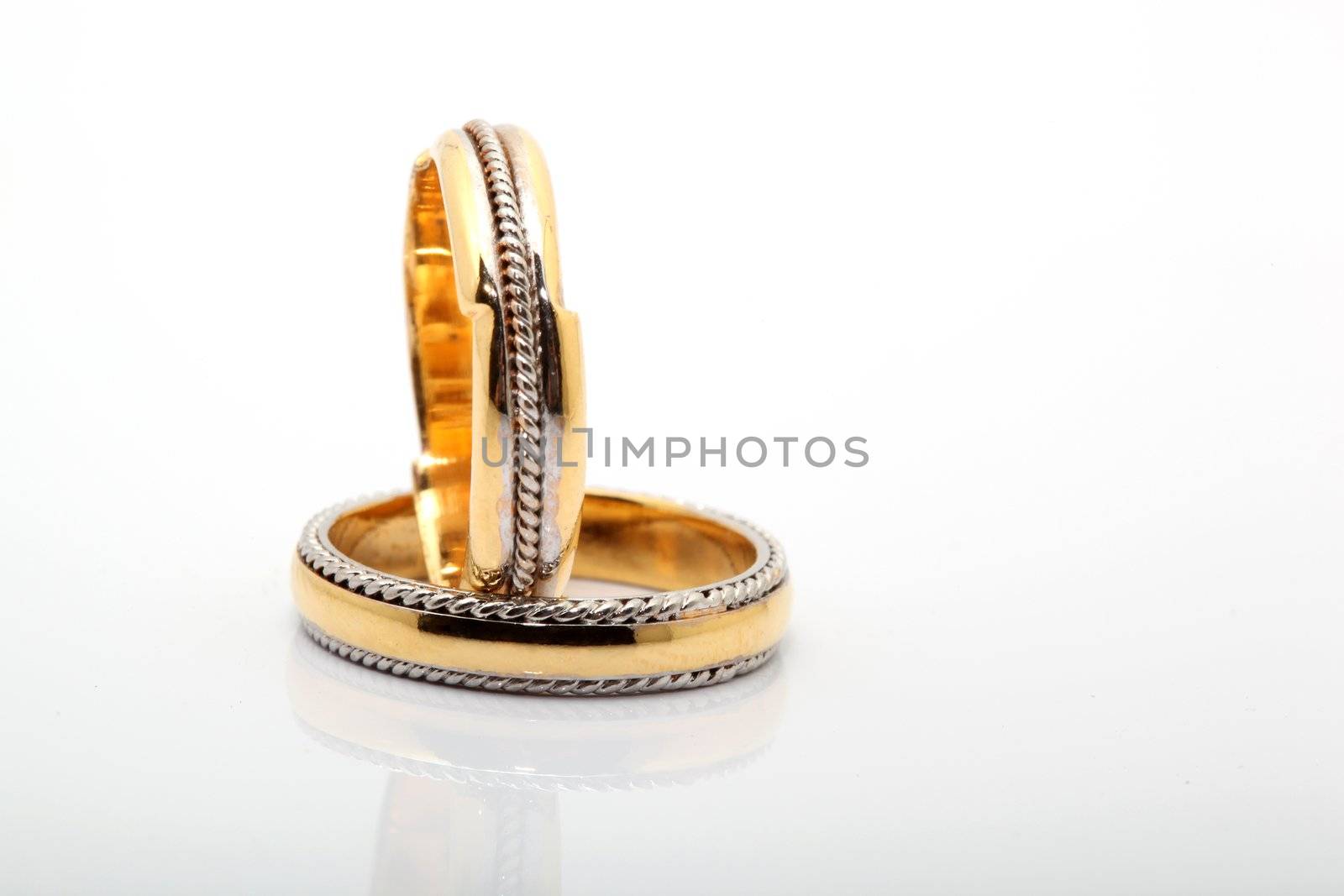 two wedding rings on white background with reflection
