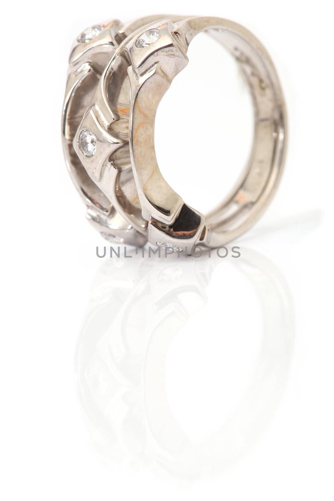 vertical closeup white gold ring with gem stones isolated and reflected