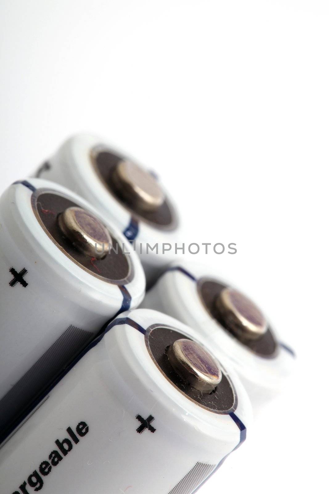 four white rechargeable batteries on white background with copyspace