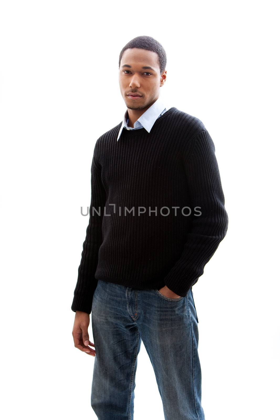 Handsome African American male in blue shirt black sweater and jeans standing, isolated