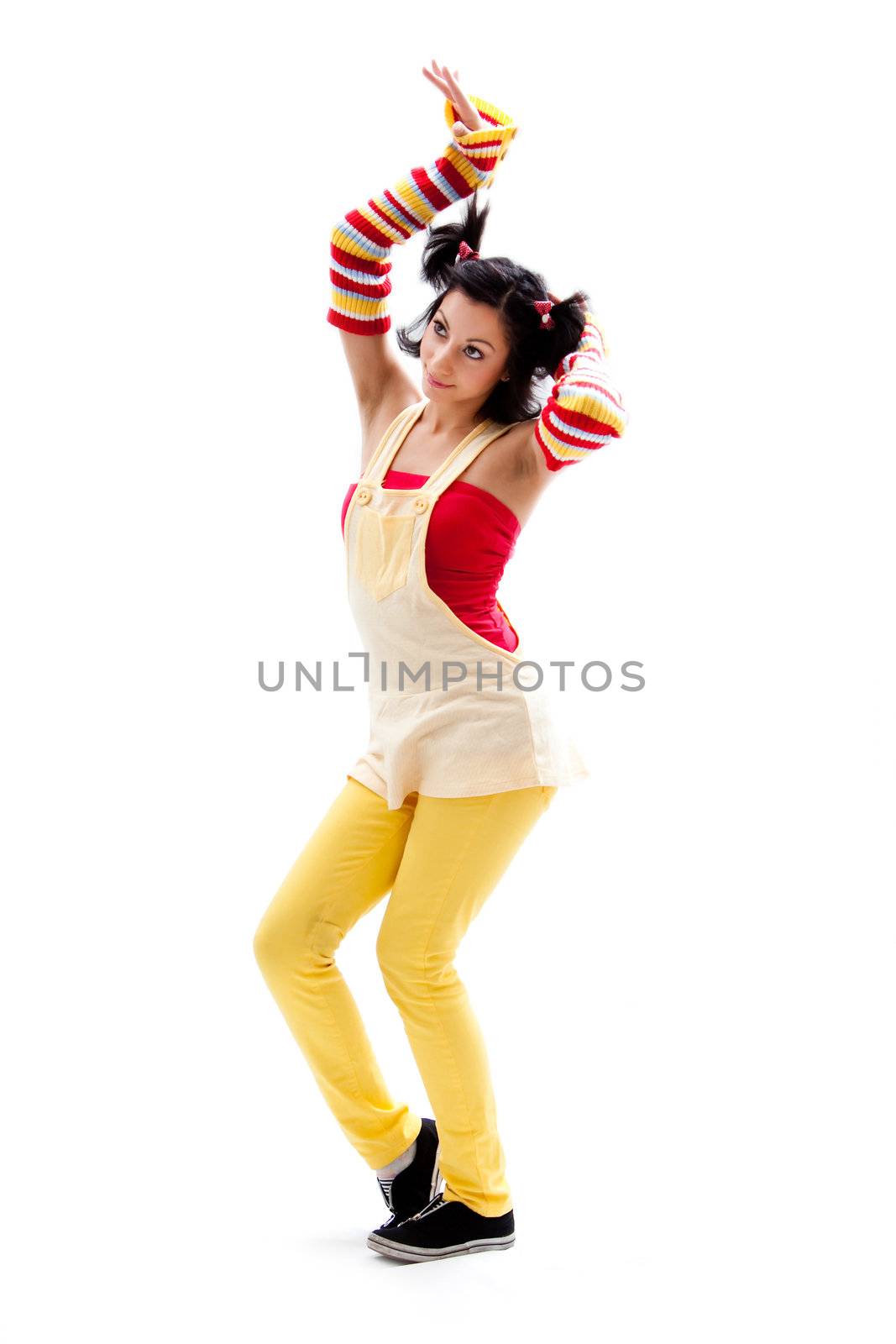 Beautiful fun latina girl with bright colored arm warmers and ponytails with red ribbons in her hair standing with hand in air, isolated