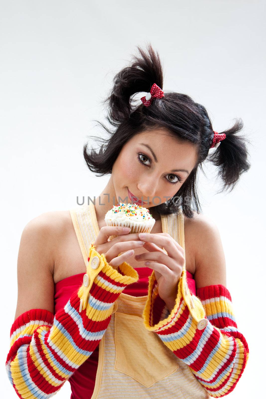 Beautiful Latina girl with huge eyes open holding a cupcake, isolated