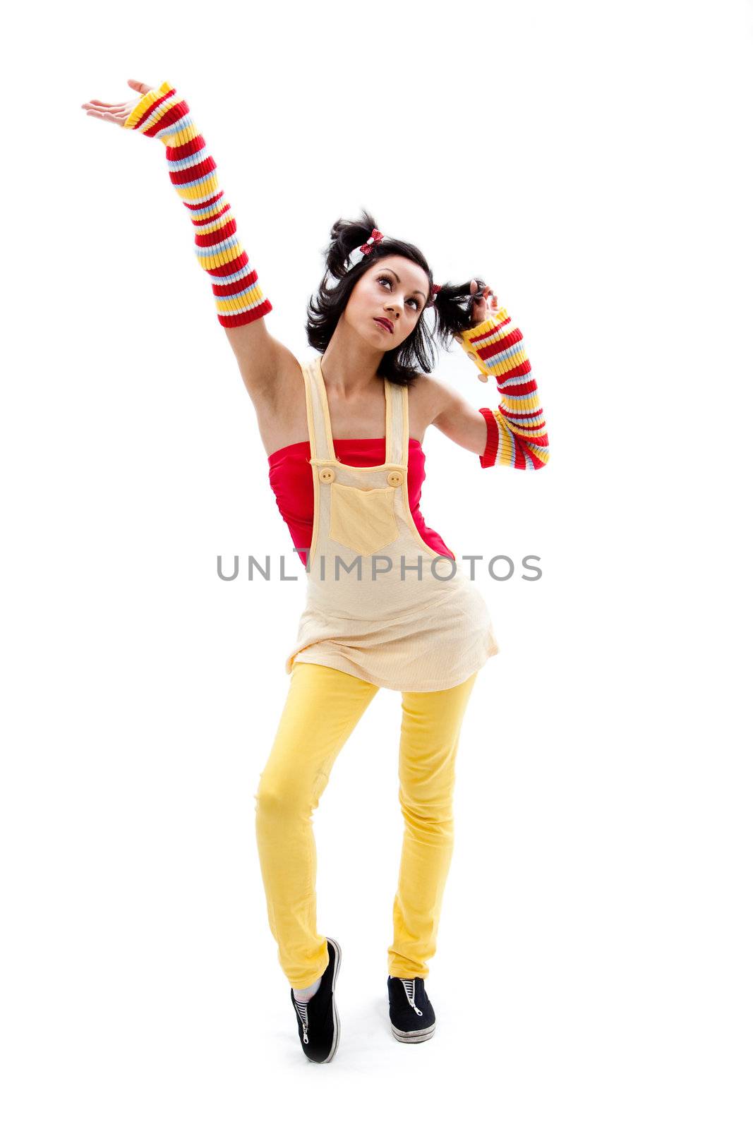 Beautiful fun latina girl with bright colored arm warmers and ponytails with red ribbons in her hair standing with hand in air, isolated