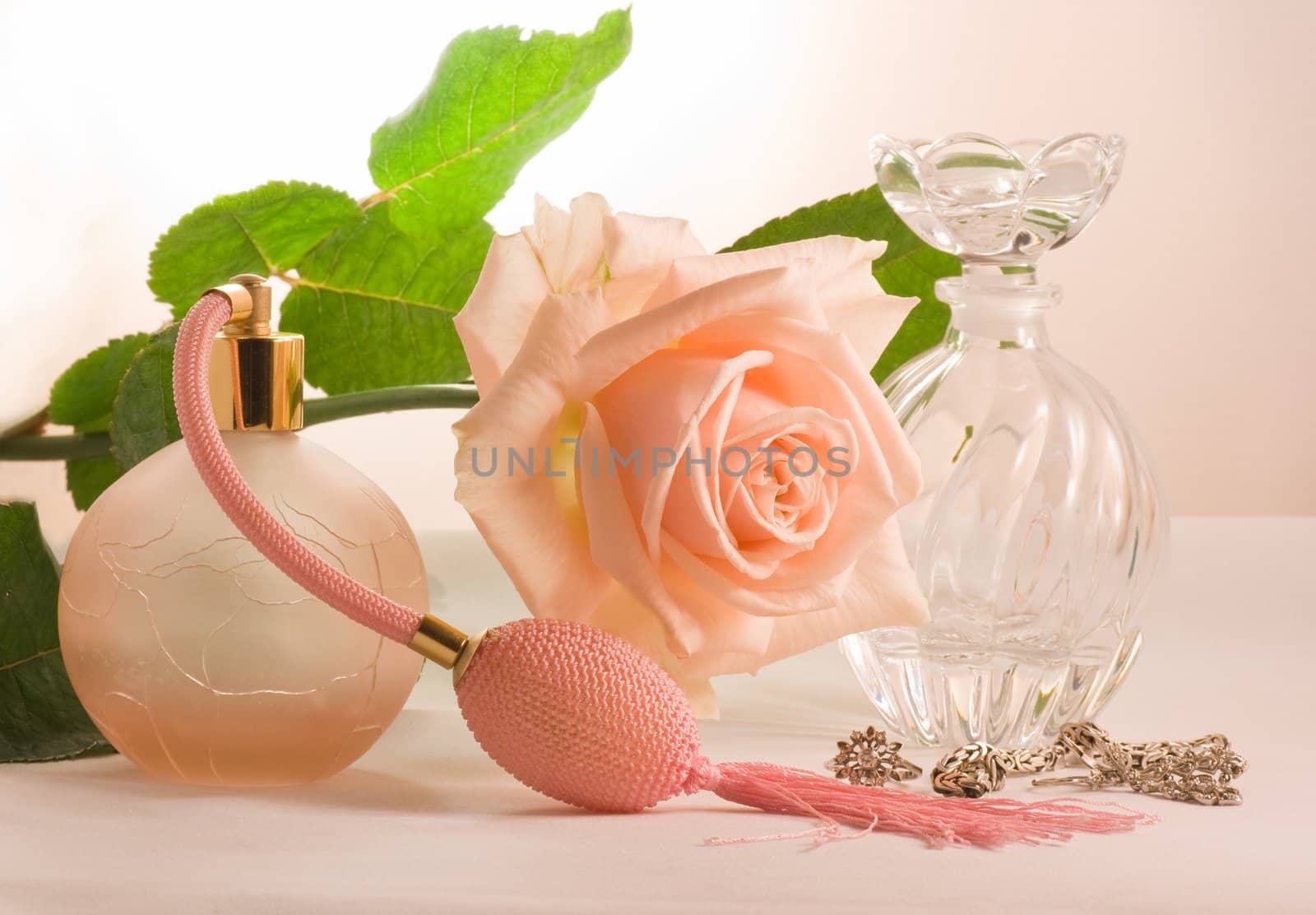 Two small bottles and soft pink rose by Colette
